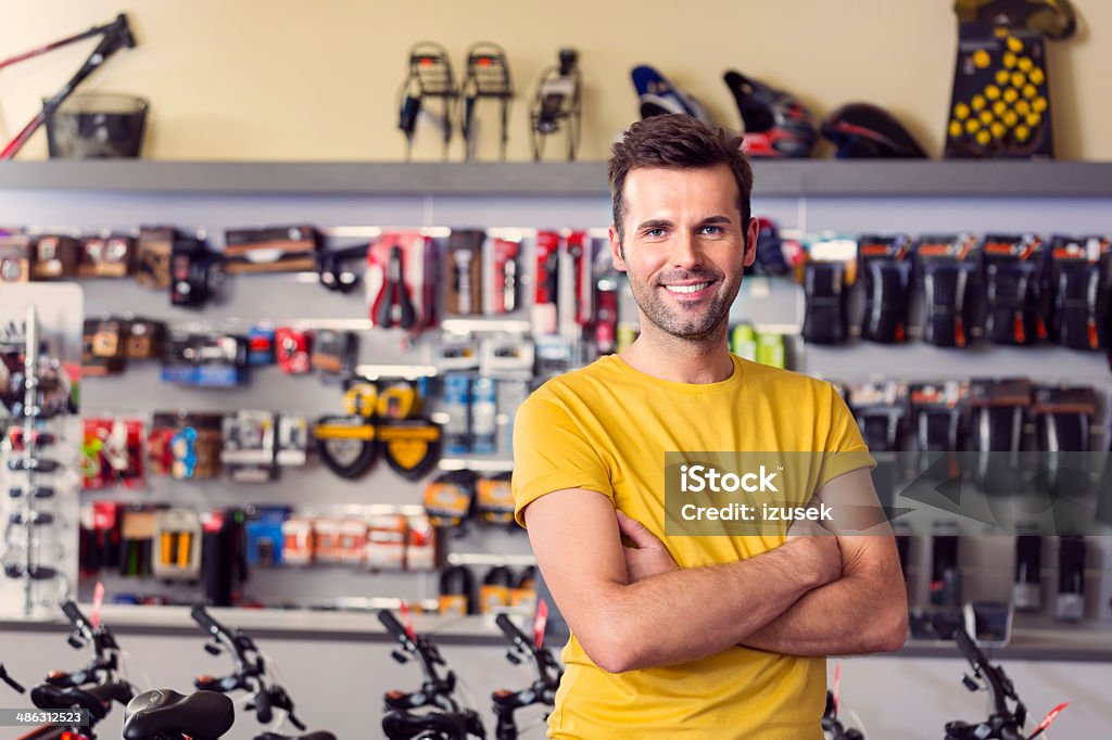 Sport store manager Portrait of manager of sports store, standing with arms crossed and smiling at camera. Retail Clerk Stock Photo