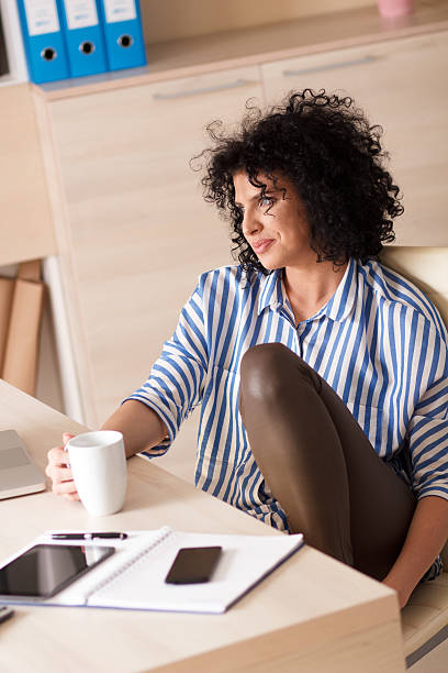 istock Young business woman taking coffee break in her office 486315052