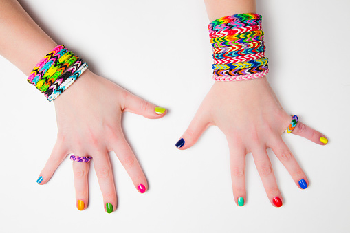 Loom bracelets on a young girl's hand. Close up. Young fashion concept