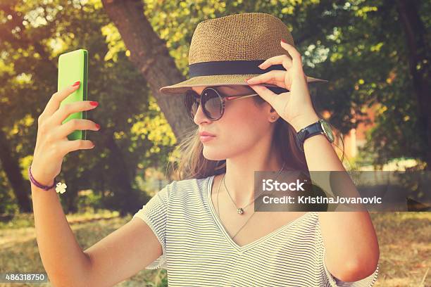 Young Woman Taking A Selfie With Cellphone На Открытом Воздухе — стоковые фотографии и другие картинки 2015