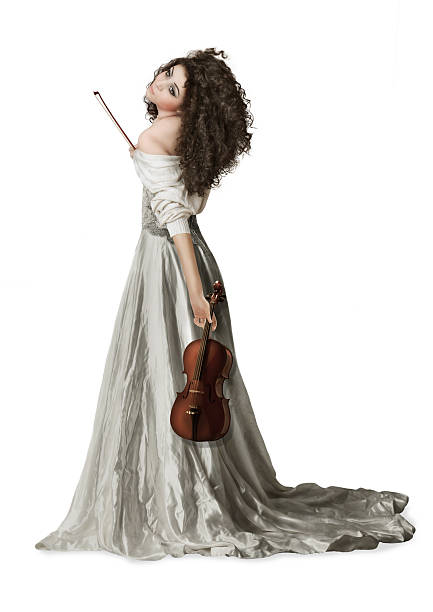 Beautiful young woman playing violin over black background.
