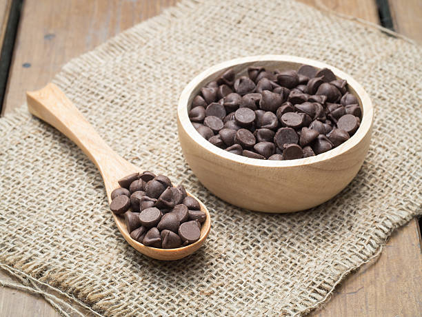istock Chocolate chips in wooden spoon and bowl 486323868