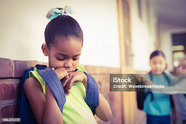 Sad Pupil Being Bullied By Classmates At Corridor Stock Photo - Download Image Now - Bullying, Child, African-American Ethnicity