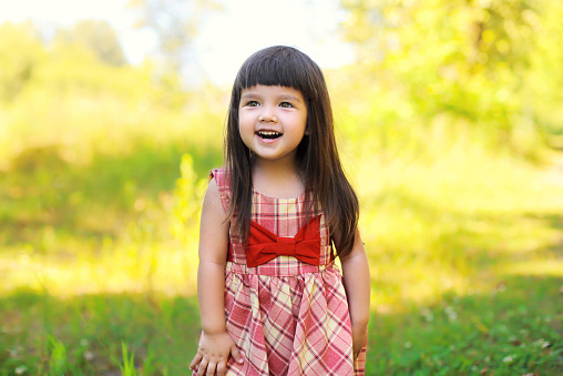 Portrait of happy smiling cute little girl child outdoors in summer day
