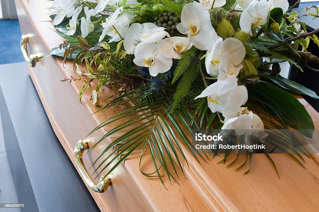 Coffin in morque A coffin with a flower arrangement in a morgue Funeral Stock Photo