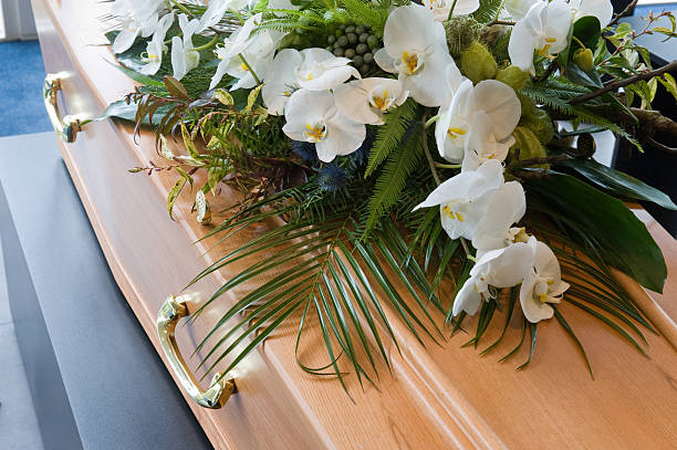 Coffin in morque A coffin with a flower arrangement in a morgue funeral parlor photos stock pictures, royalty-free photos & images