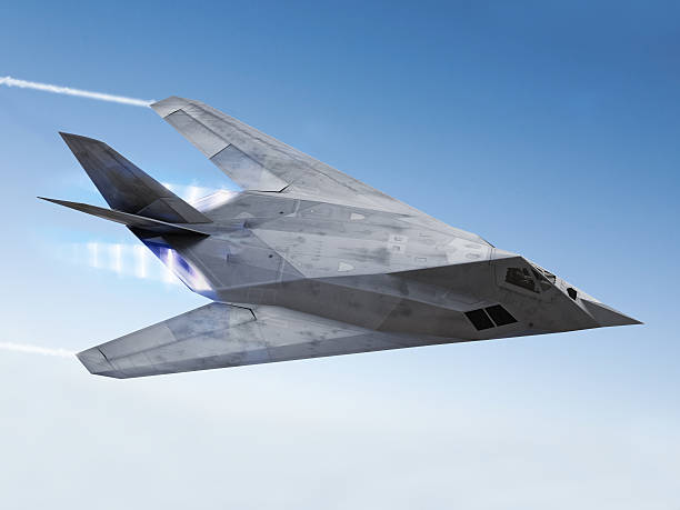 Stealth aircraft F-117 streaking through the sky with afterburners and vapor trails.  Missile stock pictures, royalty-free photos & images