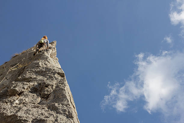 A young Caucasian woman showing excitement after climbing a mountain top on a hiking trip