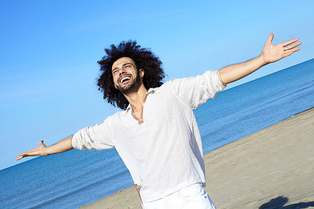 istock Happy handsome man smiling on the beach 486330941