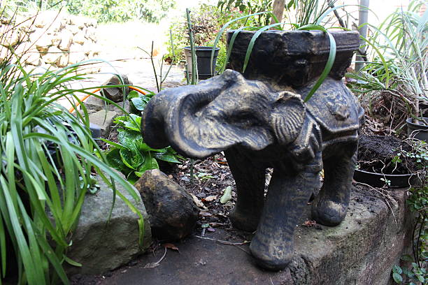 istock Elephant sculpture in the garden planted with trees 486333454