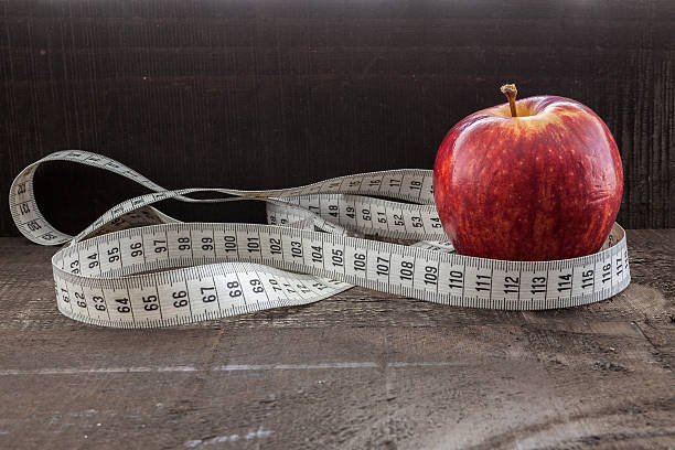 istock An Apple surrounded by a measuring tape tailor on wood 486345876