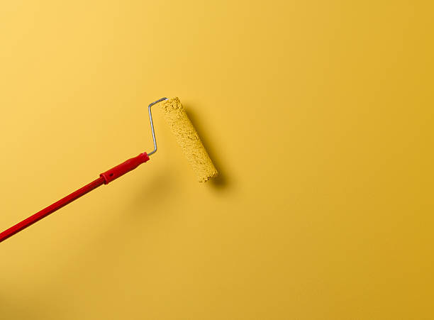 istock Paint Roller Painting The Wall In Yellow 486352386