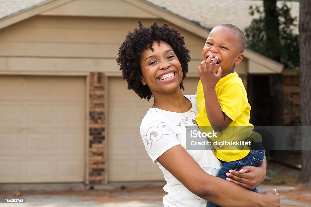 Mother and son standing in front of their new home. African American mother and her child. Child Stock Photo