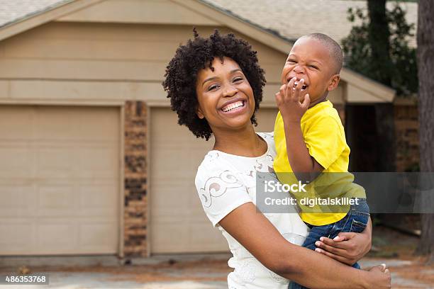 Mother And Son Standing In Front Of Their New Home Stock Photo - Download Image Now