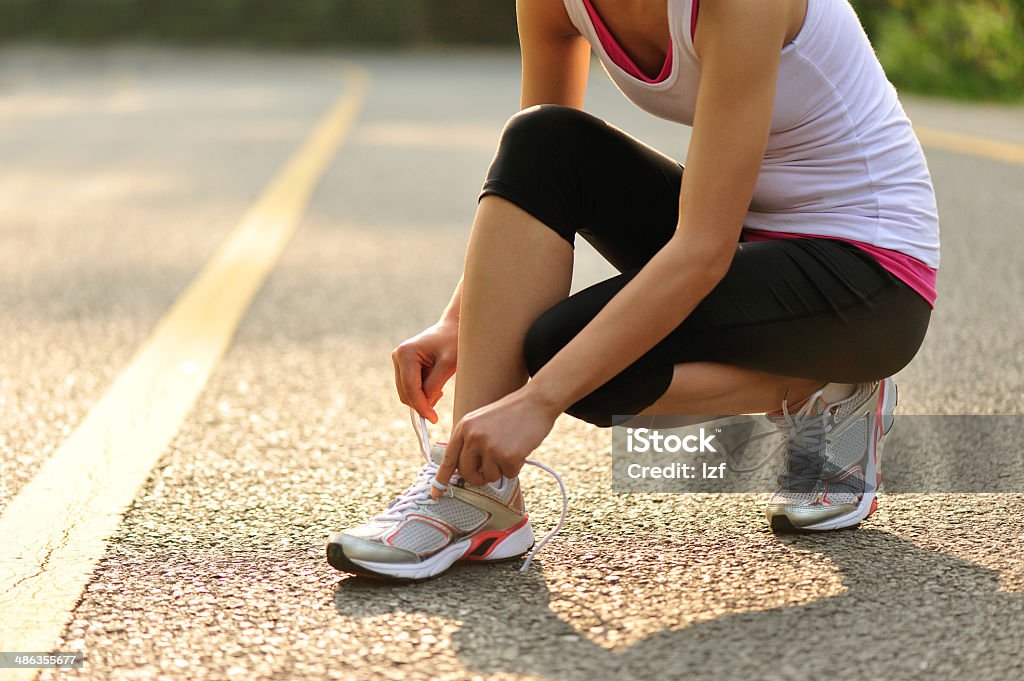 Mujer corredor anudar sports Zapatos para correr en carretera laces - Foto de stock de Actividad libre de derechos