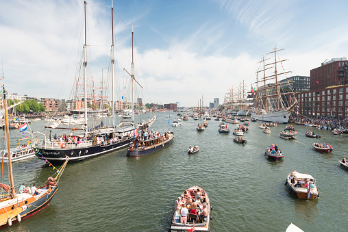 Amsterdam, the Netherlands - August 22, 2015: Color image of a busy day during the SAIL festival in Amsterdam, the Netherlands. Small passenger and hobby boats are sailing the port of Amsterdam. SAIL is the biggest festival in the Netherlands. It's a fully public event, visited around 2 million visitors, happening every five years. During the festival world famous tall ships are anchored in the harbour of Amsterdam. Small sailing boats are allowed to sail on the Ij during the festival.
