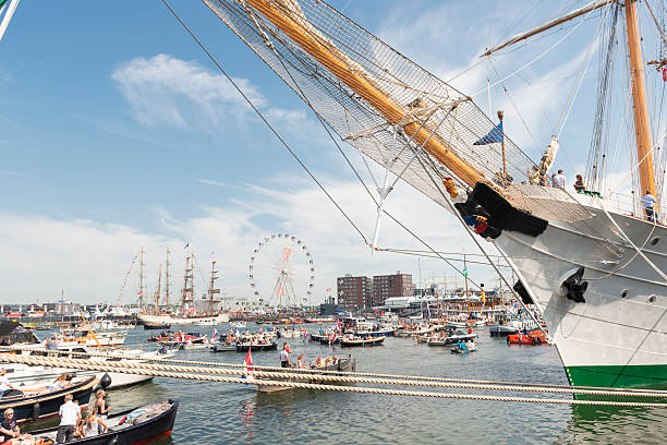 Amsterdam, the Netherlands - August 22, 2015: Color image of a busy day during the SAIL festival in Amsterdam, the Netherlands. Small passenger and hobby boats are sailing the port of Amsterdam. SAIL is the biggest festival in the Netherlands. It's a fully public event, visited around 2 million visitors, happening every five years. During the festival world famous tall ships are anchored in the harbour of Amsterdam. Small sailing boats are allowed to sail on the Ij during the festival.