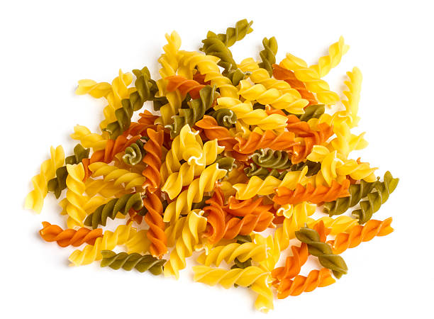istock Uncooked pasta fusilli in different colours, white background 486358491