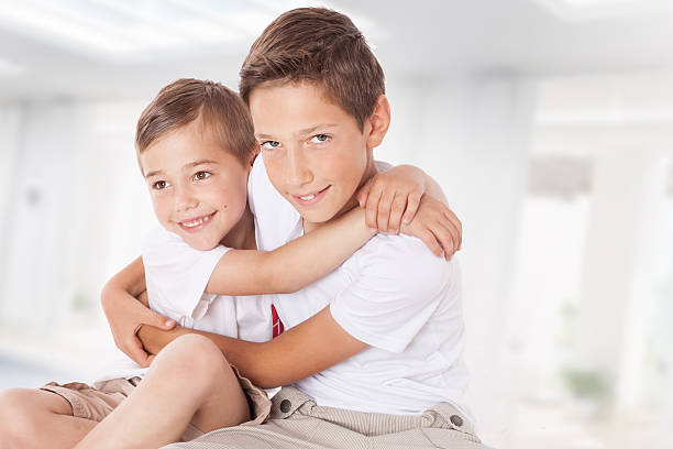 Two brothers posing at home, hugging. Family portrait.