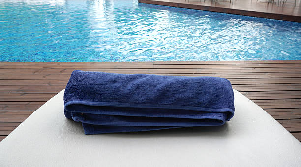 istock navy blue towel rolled on the white beach bed 486366416