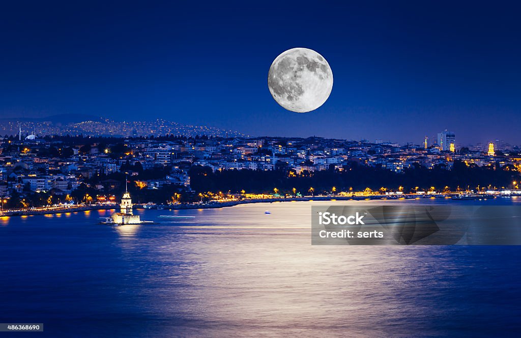 Istanbul at Night with Moon The Maiden's Tower with fullmoon and lights on sea in Istanbul, Turkey Istanbul Stock Photo