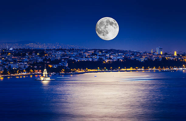 Istanbul at Night with Moon The Maiden's Tower with fullmoon and lights on sea in Istanbul, Turkey planetary moon photos stock pictures, royalty-free photos & images
