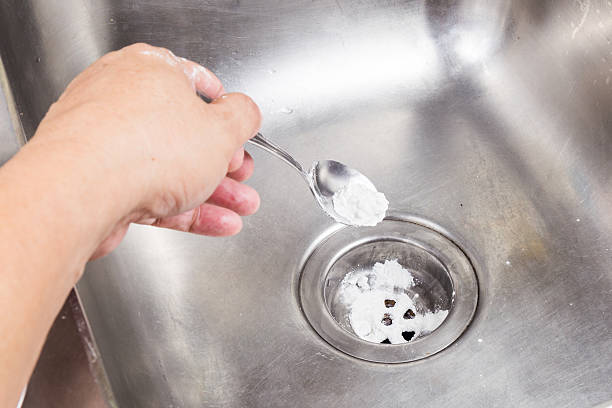bicarbonato de soda vertida para desobstruir sistema de drenagem em casa. - sink imagens e fotografias de stock