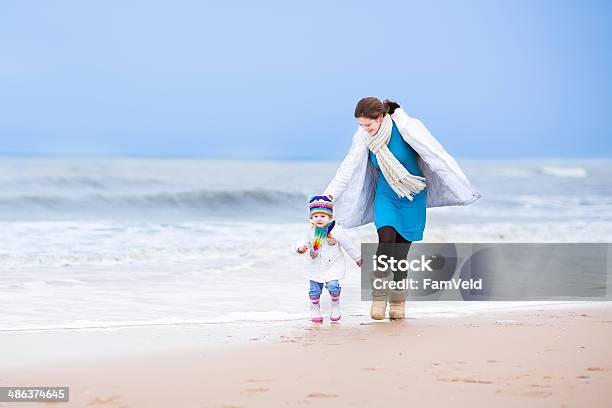 Junge Mutter Und Ihre Kleine Tochter Läuft Im Winterstrand Stockfoto und mehr Bilder von Niederlande