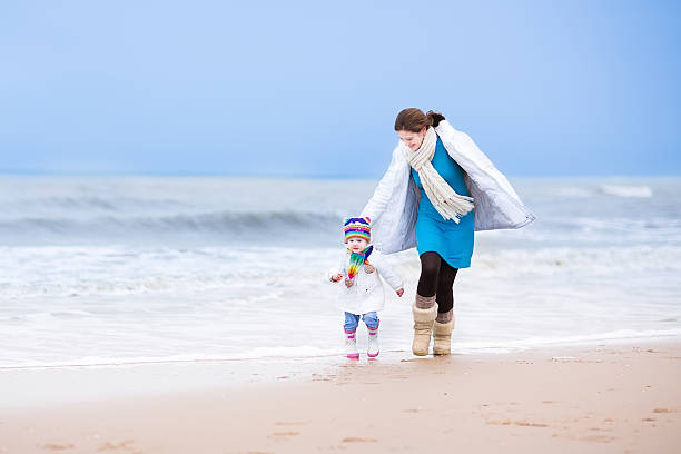 若い母と娘にて幼児冬のビーチ - women winter autumn nature ストックフォトと画像