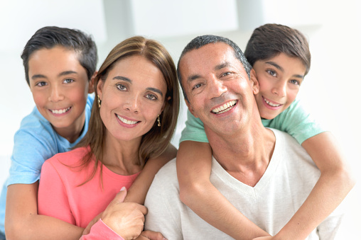 Happy Latin American family portrait at home looking at the camera and smiling