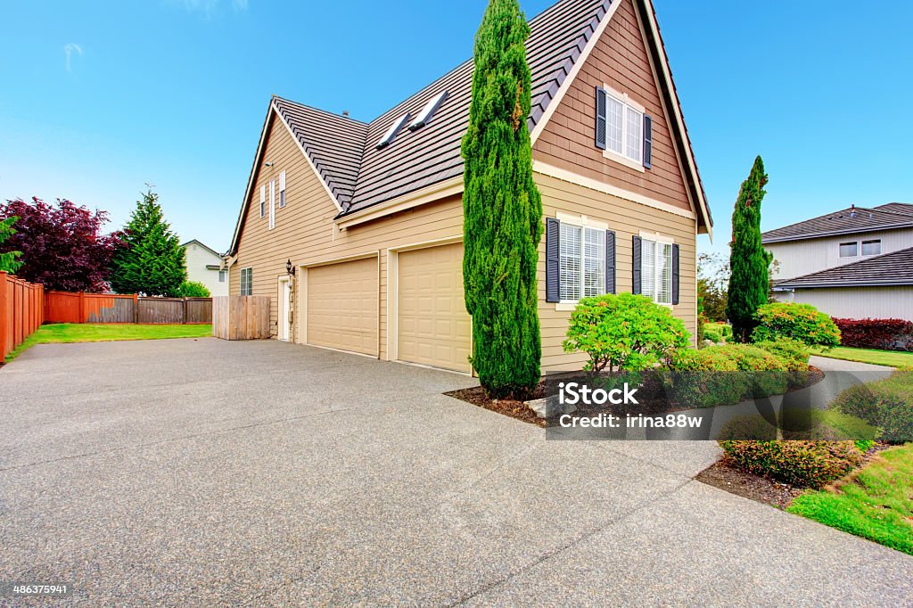 House with two car garage. Clapboard siding house with two car garage and driveway. Viw of green beautitul landscape Driveway Stock Photo