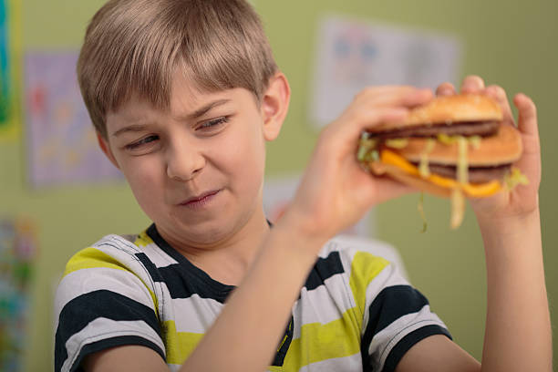 Boy don't like hamburger Unhealthy lunch - boy won't eat hamburger at school dont eat meat stock pictures, royalty-free photos & images