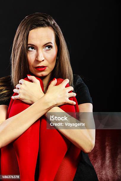 Sad Woman Sitting On Red Couch Stock Photo - Download Image Now - 2015, Adult, Adults Only