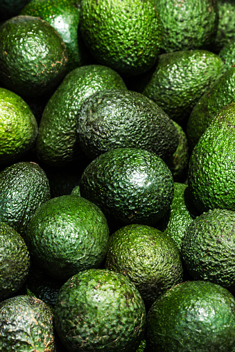 Avocado background. Fresh green avocado on a market stail. Food background.