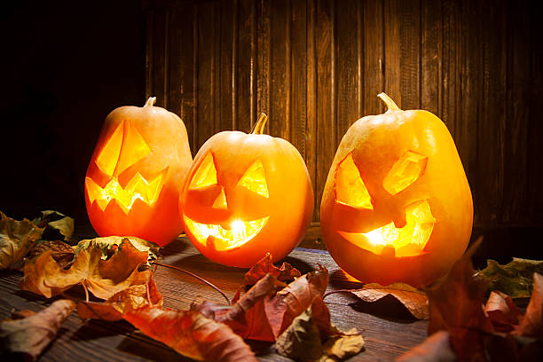 istock Jack o lanterns  Halloween pumpkin face on wooden background 486381164