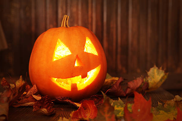 istock Jack o lanterns  Halloween pumpkin face on wooden background 486381170