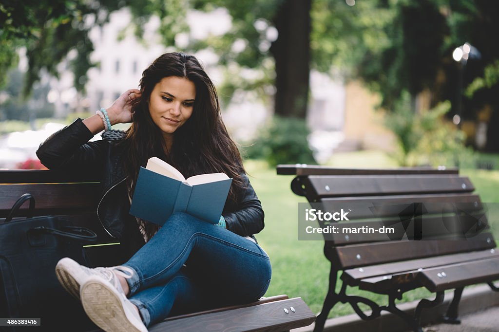 Girl reading a book in the park Girl reading a book outside Reading Stock Photo