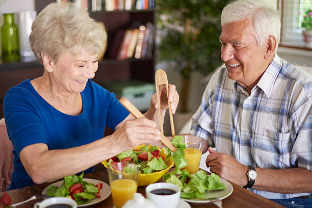 desayuno saludable comer por pareja mayor - women food smiling serving size fotografías e imágenes de stock