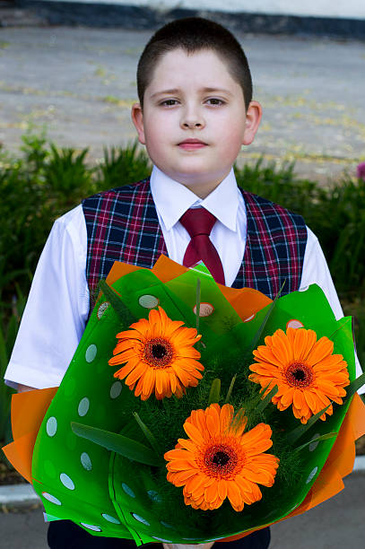 istock the school student with a bouquet orange flowers 486383702