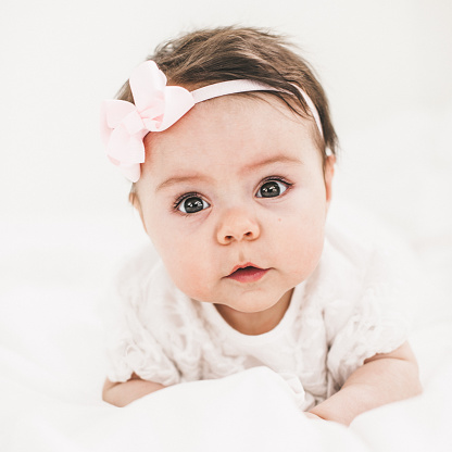 Cute baby girl lying down and looking in camera