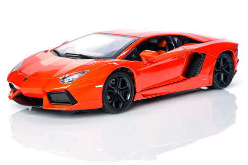Kampen, The Netherlands - September 1, 2015: Orange Lamborghini Aventador lp700-4 supercar model car by Bburago isolated on a white background with a reflection in the foreground.