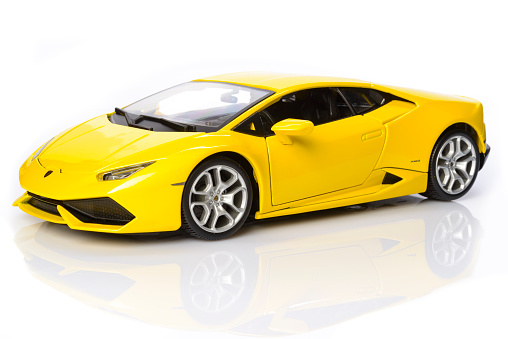 Kampen, The Netherlands - September 1, 2015: Yellow Lamborghini Huracan LP 640-4  supercar model car by Bburago isolated on a white background with a reflection in the foreground. 
