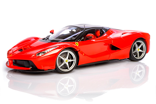 Kampen, The Netherlands - August 27, 2015: Red Ferrari LaFerrari hybrid sports car model car by Bburago isolated on a white background with a reflection in the foreground.