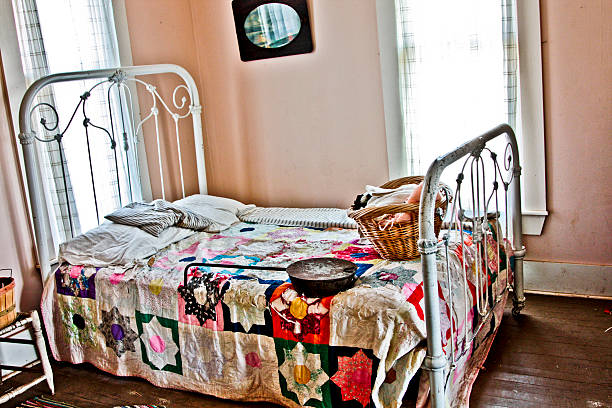 An old time antique iron bed with colorful quilt.
