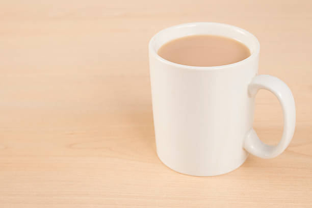 A glass teapot with tea and a cup of tea on the table