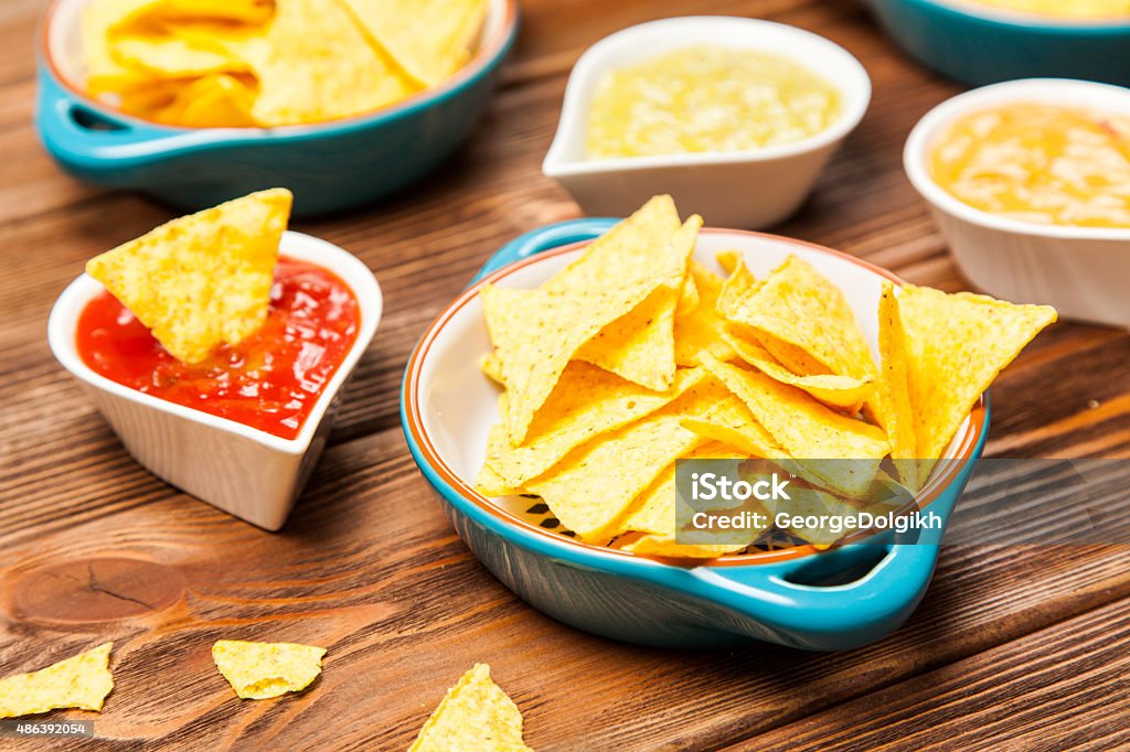 Plate of nachos with different dips Plate of nachos with salsa, cheese and guacamole dips 2015 Stock Photo