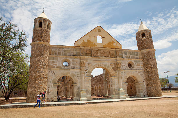 Cuilapam de Guerrero, Mexico - May 8, 2014: The Ex-monastery of Santiago Apostol. The ancient monastery is located in the town of Cuilapam de Guerrero in the Mexican state of Oaxaca. Some locals walking in front of the complex.