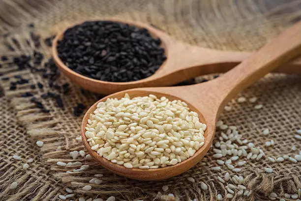 Photo of White sesame and black sesame seed on wooden spoon