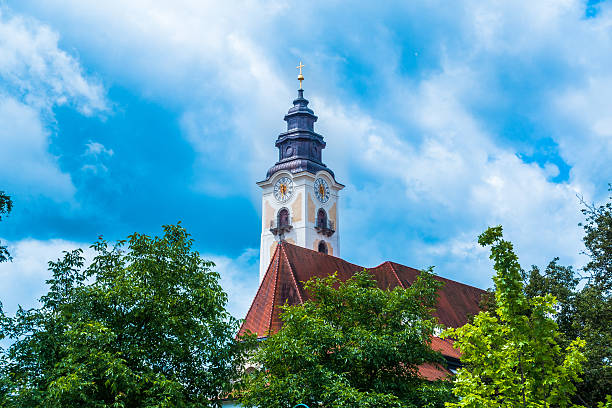 Church behind some trees Church, Eferding, trees, blue sky, red roof. eferding district stock pictures, royalty-free photos & images