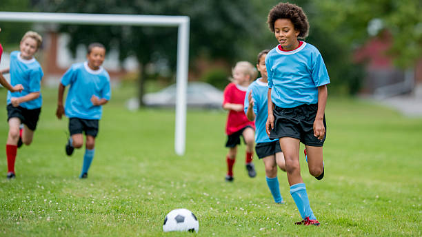 istock Boy Kicking Soccer Ball Down the Field 486401394